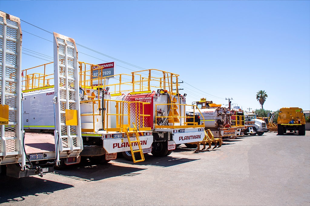 A variety of Plantman service trucks parked in an outdoor yard, ready for fleet operations.